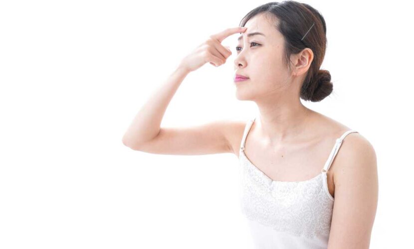 おでこの凹んだ傷跡を治す方法を探している女性のイメージ